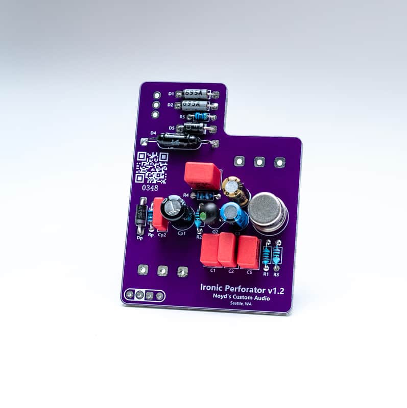 The Ironic Perforator v1.2 circuit board: purple PCB with film capacitors, transistor cans, and labeled component positions